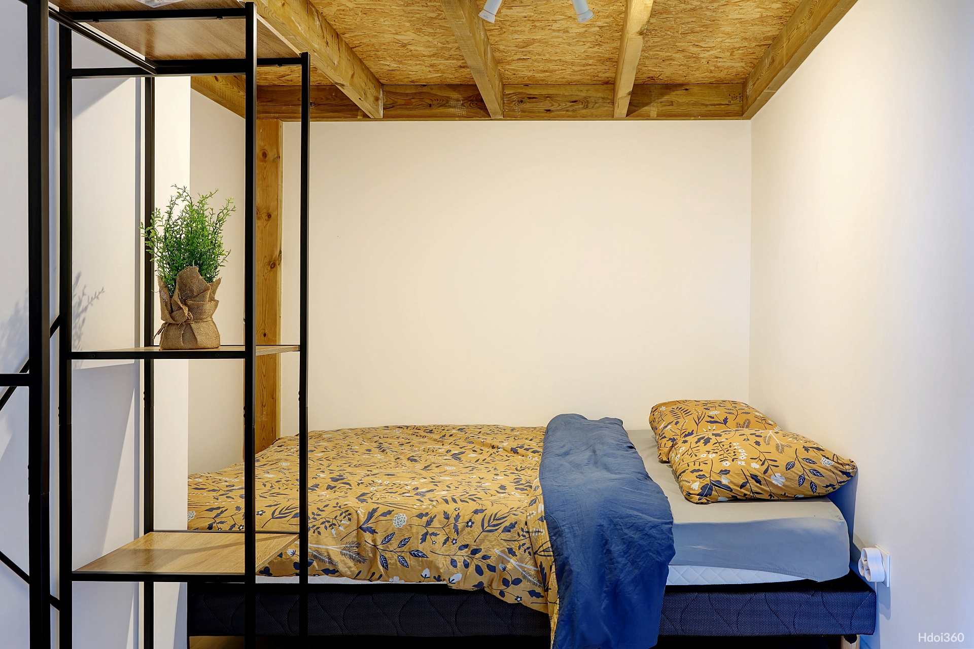 Chambre avec lit double et étagère industrielle
