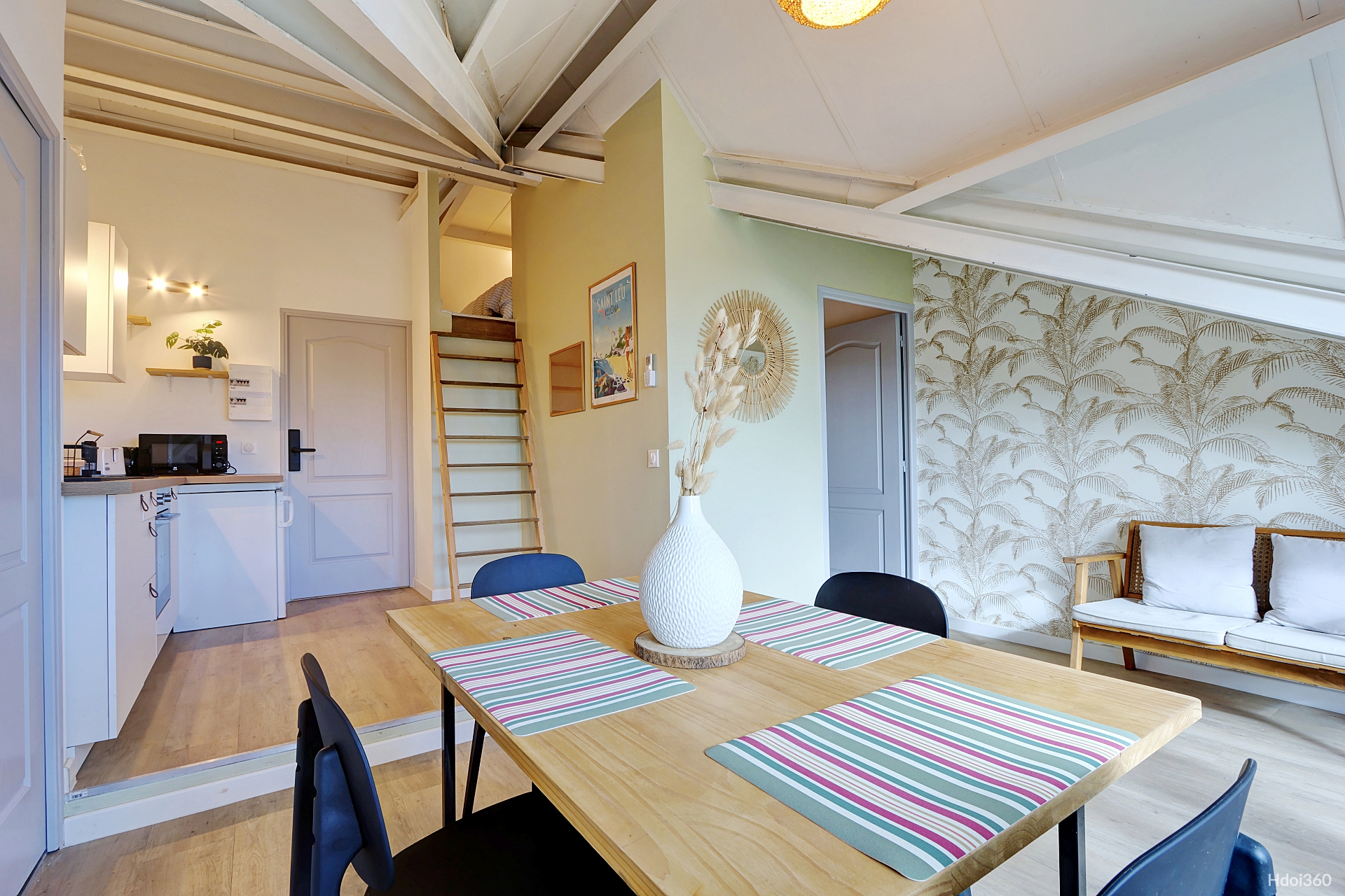 Séjour avec papier peint palmiers et escalier mezzanine