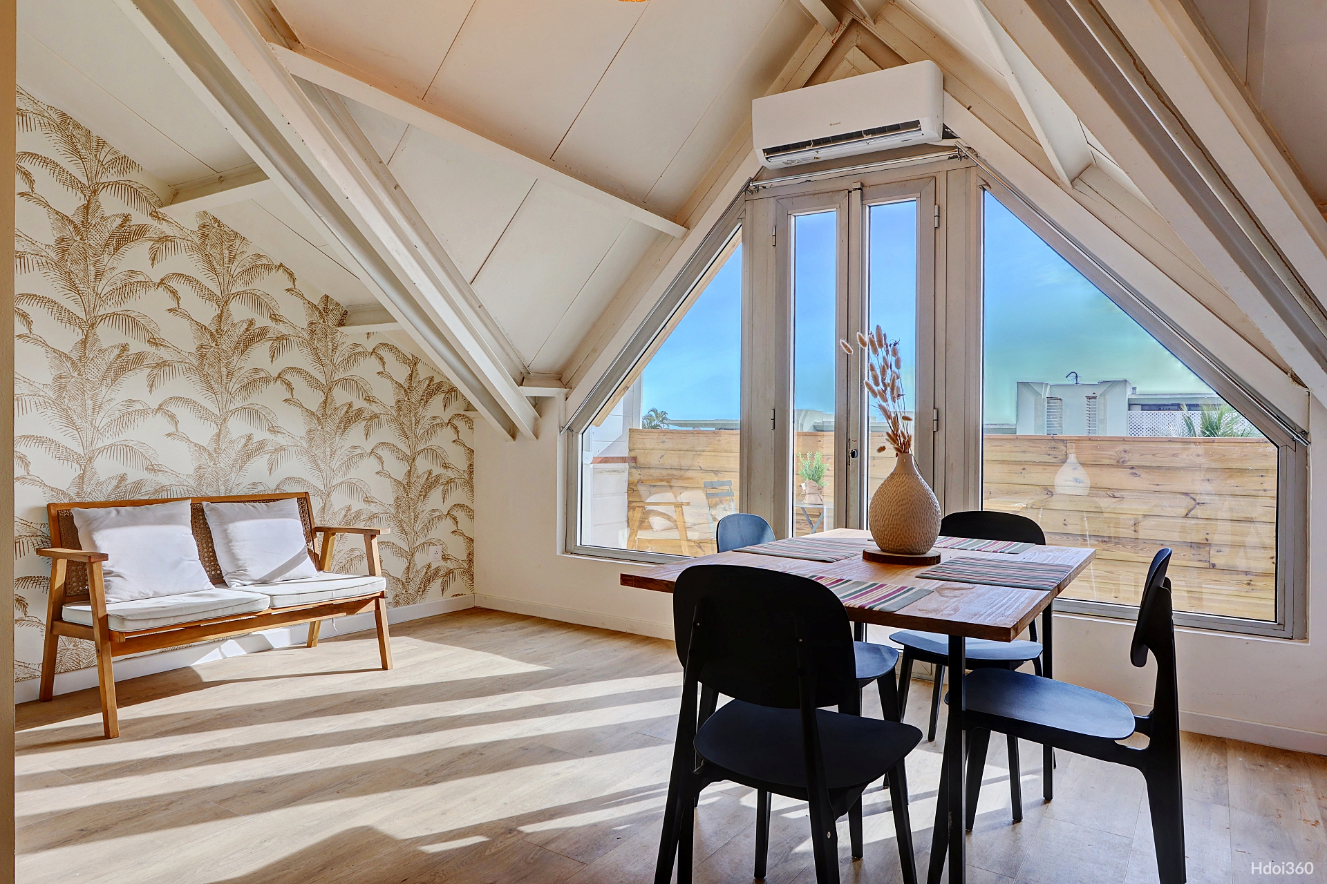 Séjour lumineux avec grande fenêtre triangulaire et terrasse